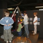 Kinder stehen in einem dunklen Ausstellungsraum