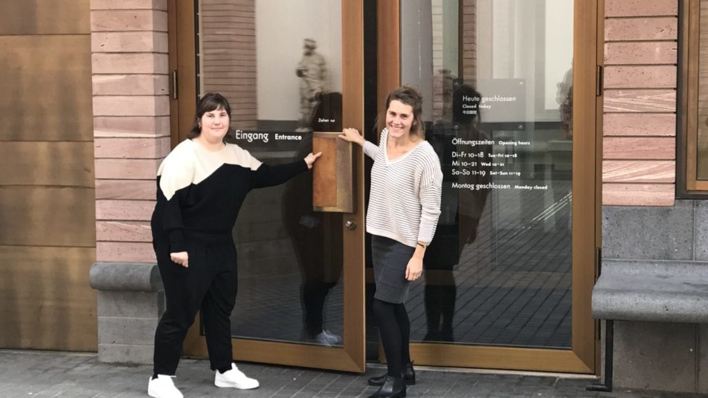 zwei Frauen stehen vor der Eingangstür des Museums