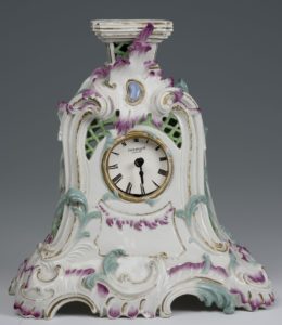 Uhrengehäuse aus Porzellan mit geschwungener, floraler Dekoration in grün und rosa