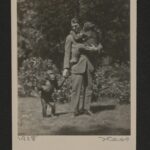 Schwarzweisß-Fotografie: ein Mann im Anzug häkt einen Affen im Arm, ein andere Affe steht neben ihm