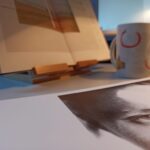 Blick auf einen Schreibtisch mit Buch und Fotografie