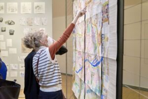 Zwei Frauen stehen vor dem Ausstellungsbeitrag Frankfurter Flanierkarte. Sie zeigt eine künstlerische wahrnehmungskarte von Frankfurt.
