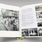 Ein großes aufgeblättertes Buch. Auf der linken Seite ein großes schwarz-weiß Foto aus den 1960er JAhren mit verkleideten Kindern. Auf der rechten Seite ein Text "Verschwundene Häuser" und schwarz-weiß-Fotos von Personen.