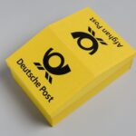 Nachbildung eines Briefkastens in gelb mit dem Posthorn der deutschen Bundespost